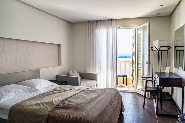 A hotel room with a large window overlooking the ocean